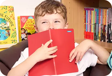 ragazzino che tiene il libro davanti con un piccolo adesivo su di esso