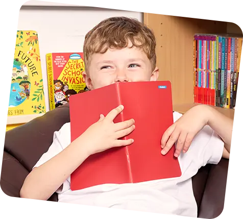 ragazzino che tiene il libro davanti con un piccolo adesivo su di esso